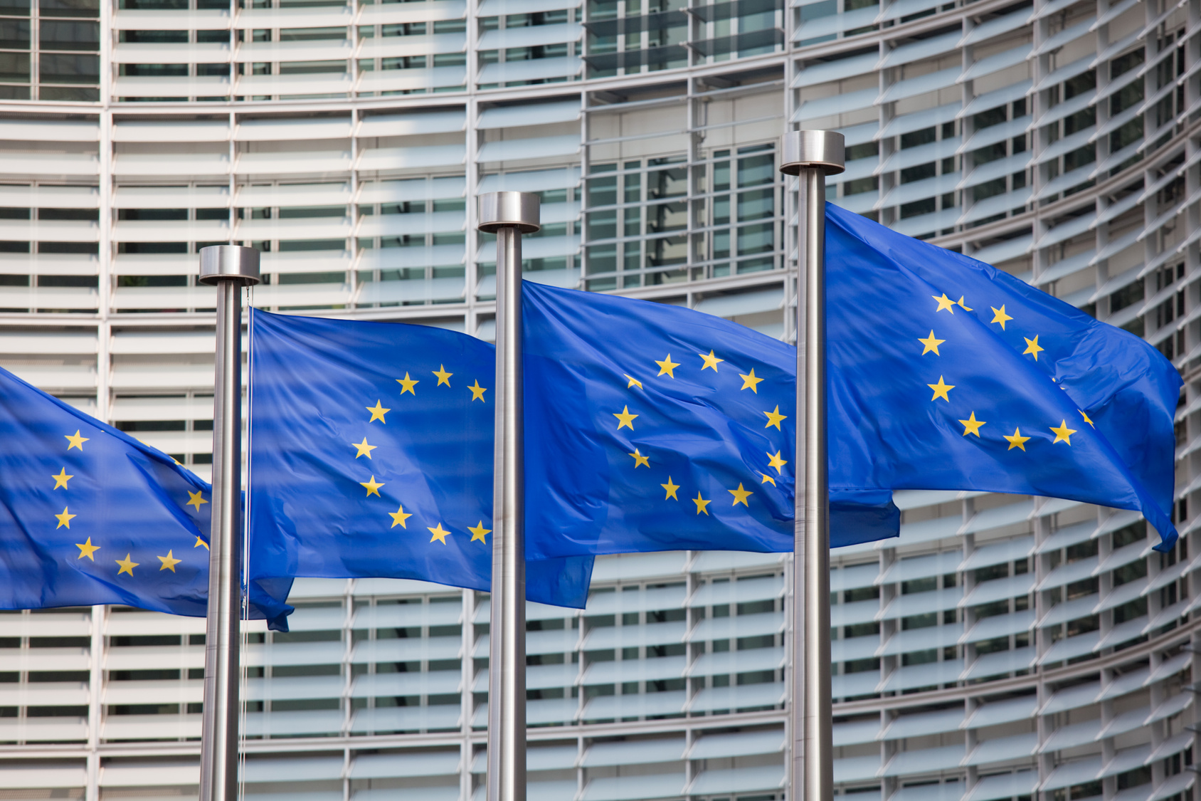 Flagi UE na tle gmachu Komisji Europejskiej