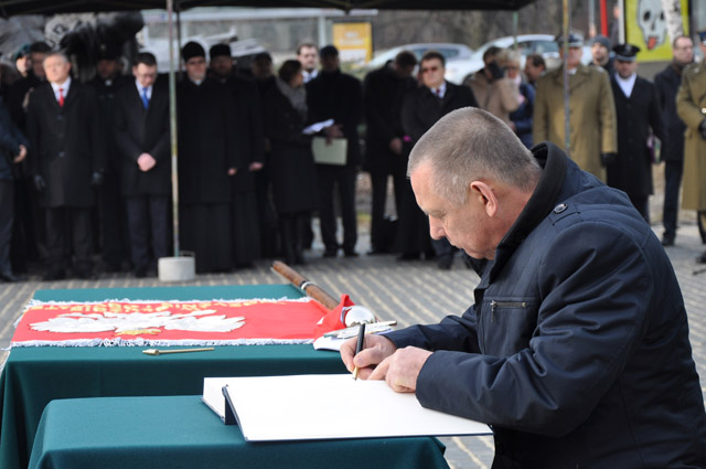 Szef Krajowej Administracji Skarbowej Marian Banaś dokonuje wpisu w księdze pamiątkowej