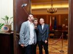 Trzech finalistów konkursu radośnie pozuje do selfie z gabinetem ministra w tle.