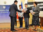Minister Leszek Skiba wręcza dyplomy trzyosobowej grupie nagrodzonych gimnazjalistów i ich opiekunce.