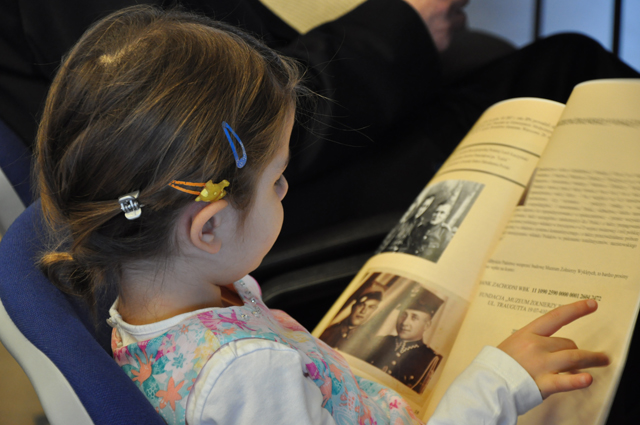 Dziewczynka czytająca przed rozpoczęciem konferencji broszurę nt. „Żołnierzy Niezłomnych