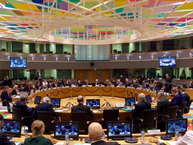 Uczestnicy siedzą przy okrągłym stole podczas posiedzenia Rady ECOFIN w Brukseli.
