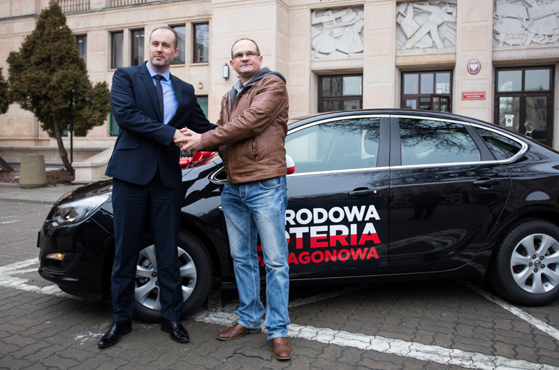 Minister Konrad Raczkowski i pan Piotr z Włocławka przy samochodzie Opel Astra.