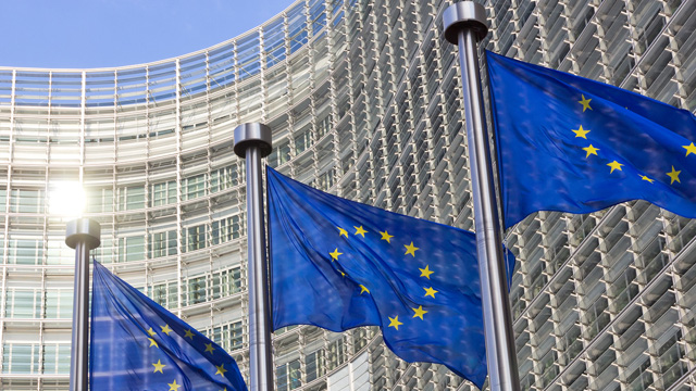 Flagi UE na tle budynku Komisji Europejskiej