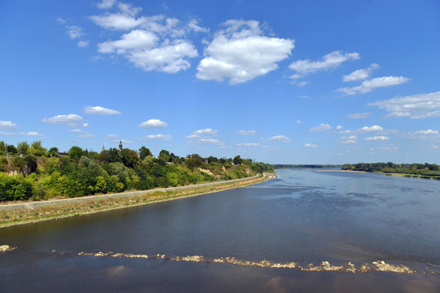 Panoram lewego brzegu rzeki na którym widać wał przeciwpowodziowy