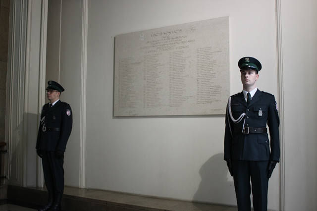 Funkcjonariusze celni pełnią wartę honorową przy tablicy pamiątkowej. 