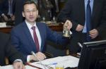 Wicepremier Mateusz Morawiecki trzyma w dłoni dzwonek podczas spotkania ECOFIN w Brukseli