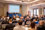 Uczestnicy siedzą w sali konferencyjnej.