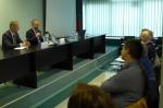 Minister Cybulski siedzi przy stole prezydialnym, przemawia do przedsiębiorców.