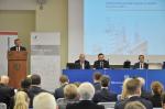 Na zdjęciu Szef KAS M.Banaś podczas wystąpienia, uczestnicy przy stole prezydialnym, widoczny slajd z tytułem konferencji Przeciwdziałanie szarej strefie