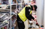 Na zdjęciu zabezpieczone towary, widoczny funkcjonariusz KAS