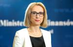 Minister finansów Teresa Czerwińska na niebieskim tle w tym rozmyty napis Ministerstwo Finansów 