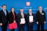 Na zdjęciu uczestnicy spotkania, na tle ścianki z napisem Krajowa Administracja Skarbowa