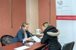 Na zdjęciu konsultantka i podatniczka, po prawej stronie widoczny roll-up z logo KAS i adresem strony www.mazowieckie.kas.gov.pl