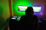Na zdjęciu funkcjonariusz KAS, na stole nielegalne urządzenia hazardowe, na ścianie widoczne zamontowane monitory do gier.