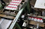 Na zdjęciu fragmenty maszyn do produkcji papierosów, widoczne paczki papierosów na linii produkcyjnej.