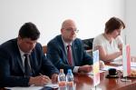 Widok na stół prezydialny, widoczni z-ca Szefa KAS Piotr Walczak, z-ca Szefa Krajowego Zarządu Fiskalnego Bogdan Lari Mihei i tłumaczka.